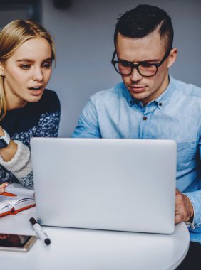 Kablosuz internet kullanarak internet sitesini tartışan iki zeki öğrenci. Bilgisayarda özel ders izleyen genç erkek ve kadın web mağazası geliştirme fikirleri hakkında konuşuyorlar.