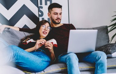 Genç evlilik biletleri ve otel internetten modern dizüstü bilgisayardaki 4G internet bağlantısını kullanarak birlikte seyahat edebilmek için. Aşıklar, şık bir apartmanda internet sitesinde bilgi arıyorlar.