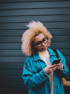 4G kablosuz interneti taramak ve web sitesinde takipçilerle sohbet etmek için şık giyinmiş Afro-Amerikalı hippi kız, çekici bayan öğrenci medya dosyası