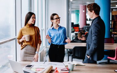 Kafkasyalı genç erkek ve kadın meslektaşlar başarılı proje ve ara verme fikirlerini tartışıyorlar.
