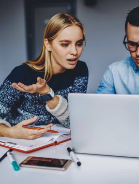 Kablosuz internet kullanarak internet sitesini tartışan iki zeki öğrenci. Bilgisayarda özel ders izleyen genç erkek ve kadın web mağazası geliştirme fikirleri hakkında konuşuyorlar.