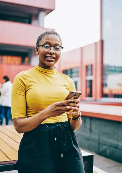 Sıradan giyinmiş ve gözlüklü Afro-Amerikalı bir kadın kameraya bakıyor ve cep telefonunu tutuyor. Akıllı telefon kullanan çekici esmer tenli bir hippi ve sohbet için 4G interneti kullanıyor.