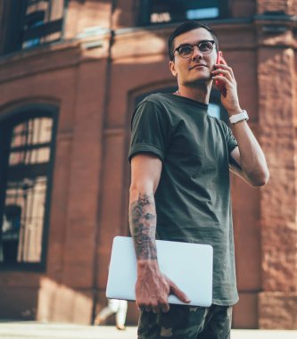 Dizüstü bilgisayarı olan yetenekli bir erkek yazılım geliştirici operatöre telefon ederek dolaşım bağlantılarının hızını ve sıcak nokta detaylarını, jenerasyon konseptini kontrol ediyor.