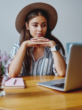 Moda giyinmiş yeniyetme kız dizüstü bilgisayarla film izliyor ve kafenin içinde kablosuz internet bağlantısı var. Kafkasyalı genç kadın netbook 'ta boş zamanlarını evde geçirmeye odaklanmış durumda.