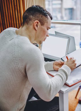 Genç bir kadın, ofis içi çalışma sırasında iş arkadaşı için belge imzalıyor. İcra Kurulu Başkanı, masaüstü bilgisayarlarıyla birlikte oturup bilgi toplamaktan gurur duyuyor.