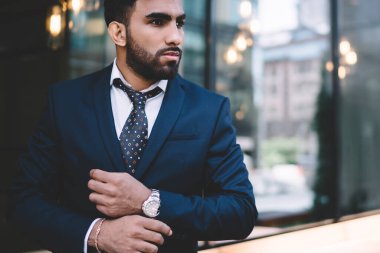 Zarif mavi takım elbiseli düşünceli, kendine güvenen İspanyol işadamı iş toplantısından önce rahat, modern bir restoranın bulanık iç mekanına karşı...