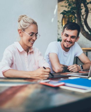 Güler yüzlü erkek ve kadın uzmanlar gündüzleri şık bir açık hava kafede farklı aletler kullanarak tele-iş yapmaktan zevk alıyorlar.