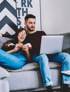 Genç evlilik biletleri ve otel internetten modern dizüstü bilgisayardaki 4G internet bağlantısını kullanarak birlikte seyahat edebilmek için. Aşıklar, şık bir apartmanda internet sitesinde bilgi arıyorlar.