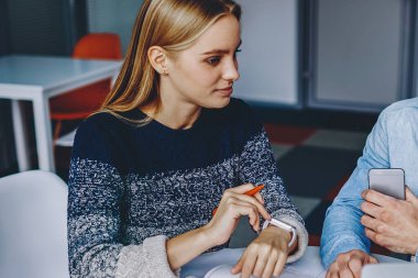 Gündelik kıyafet giyen iki öğrenci dizüstü bilgisayarlarında ders izliyorlar ve modern ofiste not defteriyle birlikte oturuyorlar. Genç adam ve kadının işbirliği ile ortak çalışma projesi hazırlıyorlar.