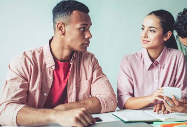 Milenyum çağındaki yenilikçi gençler masaüstünde oturuyor ve üniversite sınavına hazırlanırken cep telefonuyla 4G kablosuz internet kullanarak araştırma yapıyorlar.