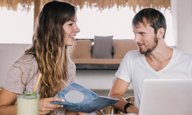 Elinde cep telefonu olan beyaz bir adam blog projesi hakkında fikir alışverişinde bulunuyor. Kadın meslektaşıyla birlikte planlama kitabının yanında oturuyor. Dizüstü bilgisayarın yanında iletişim kuran mutlu dijital göçebeler.