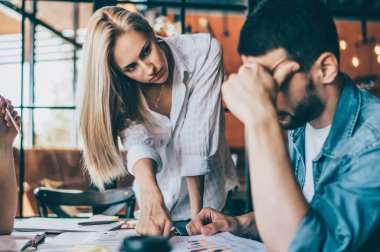 Genç bayanların kağıt çizelgesiyle kafası karışmış bir şekilde genç bir adamla konuşurken buluşmalarla ilgili bilgi vermeleri.