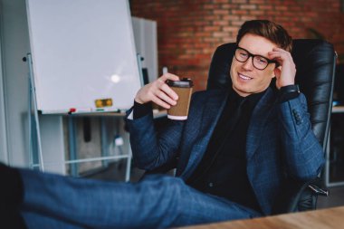 Zarif takım elbiseli ve göz giysili müreffeh işadamı hafta sonlarını iş yerinde geçirmeyi hayal ediyor.