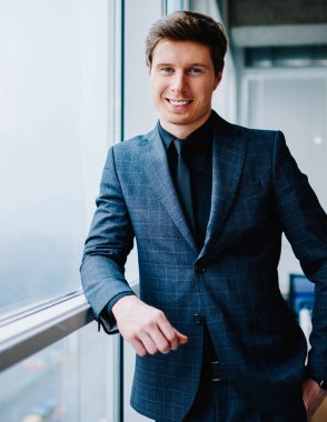 Seçkin takım elbiseli, resmi giyinmiş, başarılı bir iş adamı olarak iş hayatındaki başarısından memnun kameraya bakan zengin, beyaz tenli, şirketin sahibi erkek portresinin yarısı kadar.