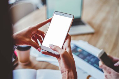 Kadınların elleri boş ekranlı dijital akıllı telefonu tutarken ve sosyal ağlarda 4G internetini kullanarak sohbet ederken görüntülenmiş. Web siteniz için kopyalama alanı olan cep telefonu.