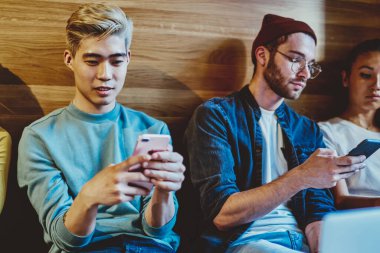 Milenyum hippilerinin akıllı telefonlarını kullanmaları gerçek sohbeti görmezden gelmeleri modern teknolojilere ve internet ağlarına bağımlı modaya uygun giyinmiş hipsterler ve akıllı telefonlar aracılığıyla sohbet etmeleri.