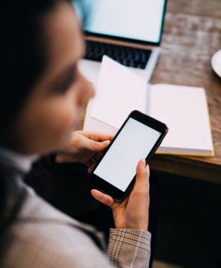 Yukarıdan gelen, uzun siyah saçlı, cep telefonuyla gezen, kahve ve not defteriyle masada oturan bayandan.