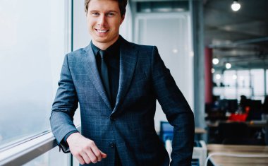 Ofiste duran zarif takım elbiseli, zengin, beyaz, erkek bir portre.