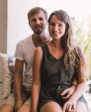 Endonezya bayramlarında pencere kenarında dinlenen ve halka açık yerlerde kameraya gülümseyen beyaz evli çiftin portresi, karı koca arasındaki ilişki ve aşk ilişkisi kavramı