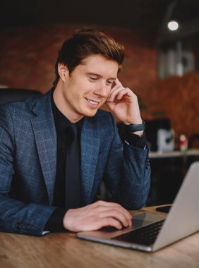 Kafkasyalı kendine güvenen erkek girişimci, web sitesinin internet sayfasında gezinen haberlerden memnun.