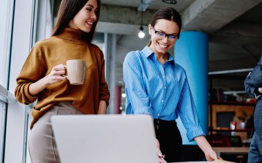 Mutlu kadın tasarımcı, ofisteki meslektaşlarıyla işbirliği yaparak tamamlanmış çizimden memnun.