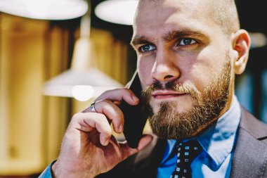 Resmi giyinmiş, kendine güveni tam bir girişimci. Akıllı telefon cihazını kullanıyor ve iş planından bahsediyor. Ofisteki dijital hücrede iletişim kuran şık takım elbiseli başarılı erkek CEO 'su.