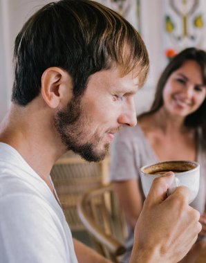 Ellerinde kahve fincanı tutan, aroması olan, sabah içkisinin tadını çıkaran, boş zamanlarında kafein içen Kafkasyalı genç adam.