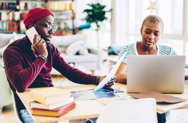 Koyu tenli bir adam, cep telefonuyla kadın meslektaşıyla çalıştığını bildiriyor. Masaüstünde kız arkadaşının yanında otururken, erkek servis operatörüne telefon görüşmesi sırasında rezervasyon yaptırıyor.