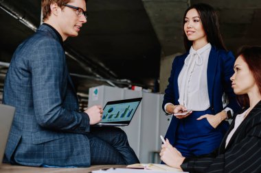 Erkek ve kadın finans uzmanlarından oluşan başarılı bir ekip, iş birliği ve beyin fırtınası üzerine bütçe planlarını tartışıyor, resmi olarak giyinmiş, iş hakkında iletişim kuran bir grup çalışanımız var.