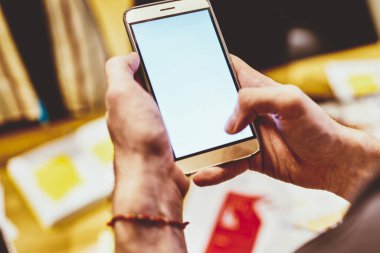 Cep telefonu tutan adamın kırpılmış görüntüsü ekran görüntüsü ile birlikte uygulama, milenyum adamı akıllı telefon kullanarak mesaj gönderiyor ve multimedya içeriğini çevrimiçi paylaşmak için web sitesini tarıyor