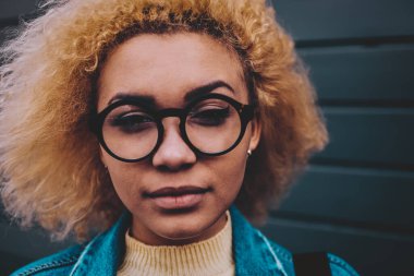 Çekici, koyu tenli, optik gözlüklü hippi kız portresi. Boş zamanlarında kameraya bakıyor. Güzel Afro-Amerikan bayan ergen.