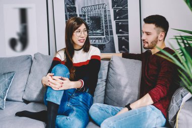 Mutlu çift evde dinlenirken sohbetten zevk alıyor, erkek arkadaş ve kız arkadaş rahat bir kanepede otururken birbirleriyle iletişim kuruyor ve evde birlikte vakit geçiriyorlar.