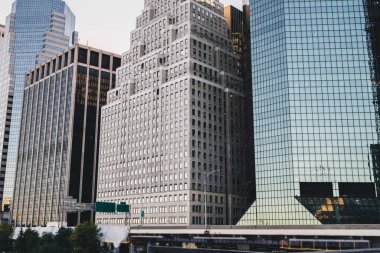 Güneşli bir günde modern metropolitan şehrinin şehir merkezinde yol kenarında cam ve betondan yapılmış uzun modern gökdelenler.