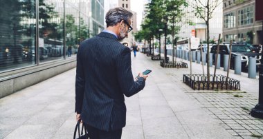 New York 'ta bulutlu bir havada Megapolis caddesinde telefon numarası yazan şık, siyah çizgili takım elbiseli başarılı bir adamın arka planı.