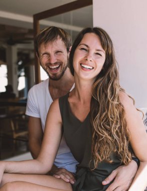Güzel görünümlü, şık giyinmiş, halka açık kafeteryada boş zamanlarında oynaşan mutlu evliliğin portresi pencerenin kenarında oturup kameraya gülen güzel bir çift.