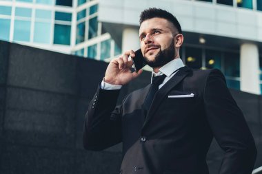 Aşağıdan kendine güvenen bir adamın akıllı telefonuyla konuşup el ele tutuşması Metropolis 'te gözlerini kaçırması.