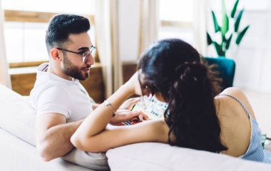 İyimser ve neşeli bir çift. Aydınlık bir odada koltukta oturup birbirlerine bakıyorlar. Konuşurken ve sosyal medyada gezinirken.