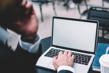 Siyah takım elbiseli bir ekin uzmanı cep telefonuyla konuşuyor ve tek kullanımlık defter ve kalemle masada çalışıyor.