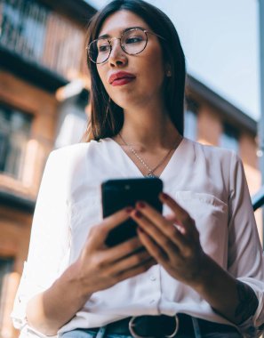 Sosyal ağlara mobil yayın yapmak için modern dijital cihaz taşıyan düşünceli içerik blogcusu, optik gösterilerde İspanyol milenyumu üzerine 4G kullanarak düşünceli içerik blogcusu