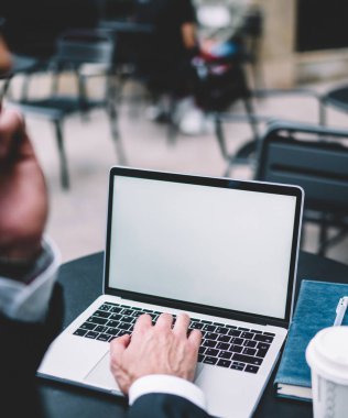 Siyah takım elbiseli bir ekin uzmanı cep telefonuyla konuşuyor ve tek kullanımlık defter ve kalemle masada çalışıyor.