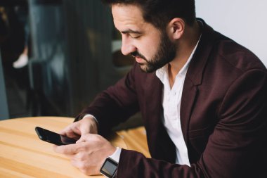 Kafkasyalı beyaz erkek girişimci, bankacılık uygulaması kullanarak akıllı telefon ile para transferi yapıyor. Kafe 'de kablosuz internet ile cep telefonuna mesaj yazan bin yıllık bir iş adamı.