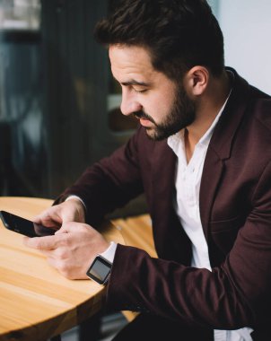 Kafkasyalı beyaz erkek girişimci, bankacılık uygulaması kullanarak akıllı telefon ile para transferi yapıyor. Kafe 'de kablosuz internet ile cep telefonuna mesaj yazan bin yıllık bir iş adamı.