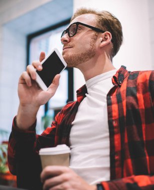 Kahveyle otururken ve akıllı telefonuyla yan yana yatıp gözlerini kaçırırken hayal kuran konsantre ve huzurlu bir adamdan.