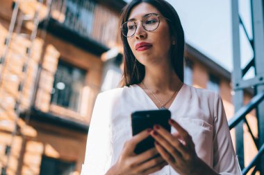 Sosyal ağlara mobil yayın yapmak için modern dijital cihaz taşıyan düşünceli içerik blogcusu, optik gösterilerde İspanyol milenyumu üzerine 4G kullanarak düşünceli içerik blogcusu