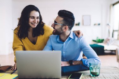 Dizüstü bilgisayarda çalışan birkaç tele-işçi, dizüstü bilgisayarda başarılı bir şekilde anlaştıktan ve birbirlerine baktıktan sonra gülümseyen kadın ve erkeklerden hoşlanıyor.