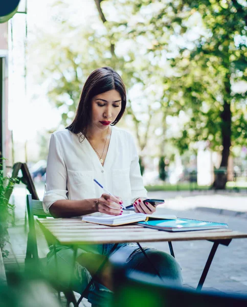 Çekici kadın blogcu, sokak kafeteryasında öğrenme sırasında interneti taramak için 4G kablosuz internete bağlı hücresel bir e-posta aldı.