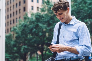 Finans bölgesinde iş molası sırasında arkadaşlarıyla sohbet eden, akıllı telefon cihazıyla 4G 'ye bağlı yakışıklı bir çalışan iletişim için cep telefonuyla şehir merkezine geliyor.