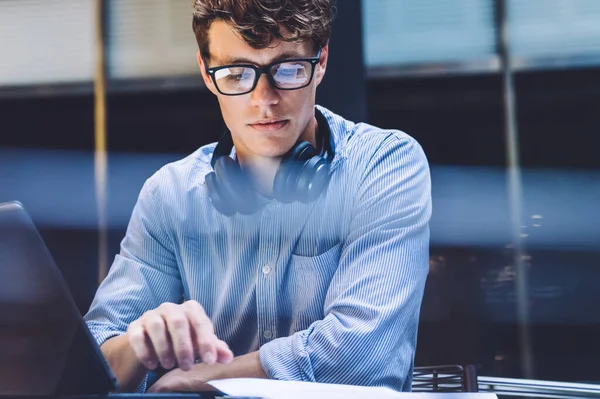 纽约市曼哈顿 一个戴着眼镜 头戴耳机 头戴平板电脑的英俊男子坐在桌旁看书 — 图库照片