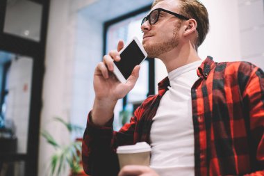 Kahveyle otururken ve akıllı telefonuyla yan yana yatıp gözlerini kaçırırken hayal kuran konsantre ve huzurlu bir adamdan.