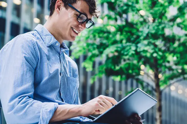在金融区工作休息期间 成功的男性创业者在社交媒体网站上与朋友聊天 戴着眼镜开心地微笑的商人享受着免费发短信的时间 — 图库照片